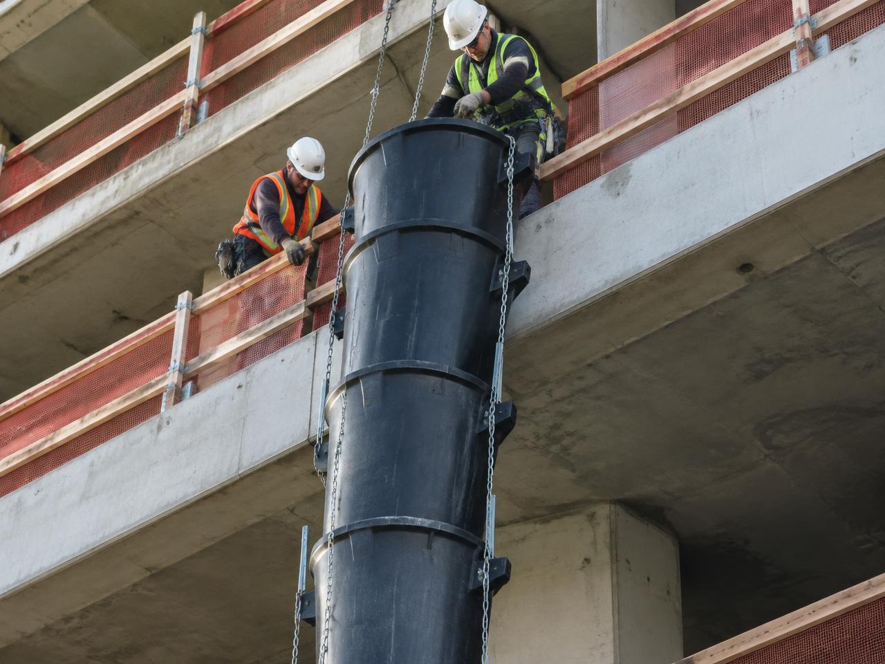 Crew installing a black sectional debris chute (illustrative photo)